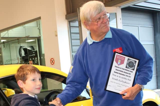 Chairman Fred Bone presented Noah with a model 911 Porsche and a certificate