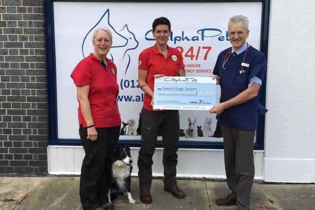 Jai Wilkes and Lu Dash, with retired search dog Skye, receive the Â£1220.79 cheque for Search Dogs Sussex from AlphaPet director Doug Alexander