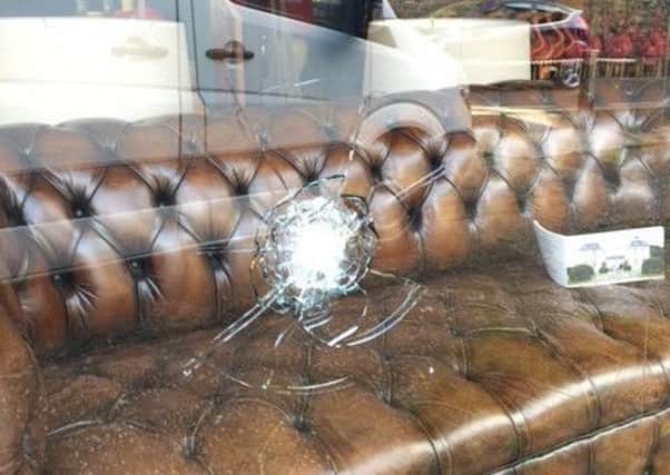 The smashed window at Anthony Short's antiques shop