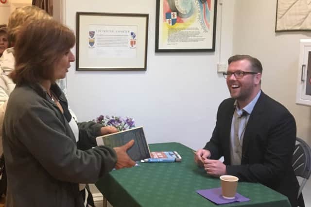 Author Damian Barr signing books