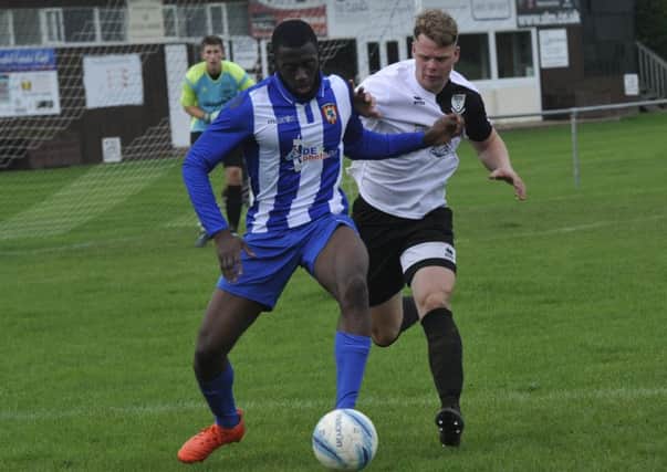 Bexhill United defender Lewis McGuigan closes down a Lingfield opponent last weekend. Pictures by Simon Newstead