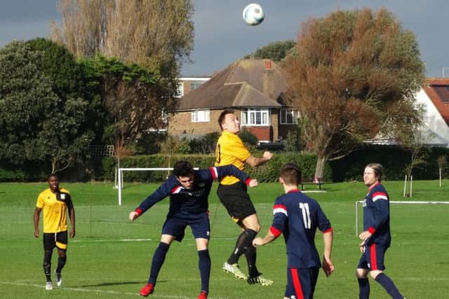 Bexhill United midfielder Gordon Cuddington gets up highest in an aerial duel. Picture courtesy Mark Killy