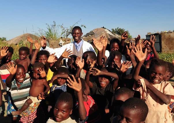 Zambian villagers and a clinician celebrate the success of The Virtual Doctors