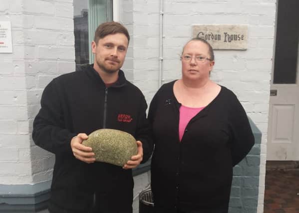 Worthing Taxis Gennaro and Philippa Higgins with the rock used to smash into her cab