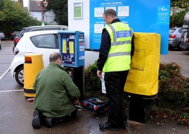 Locksmith Adrian Elliott repairs the parking meters after they were targeted by thieves in Denne Road carpark Horsham. Pic Steve Robards SR1725563 SUS-171023-134418001