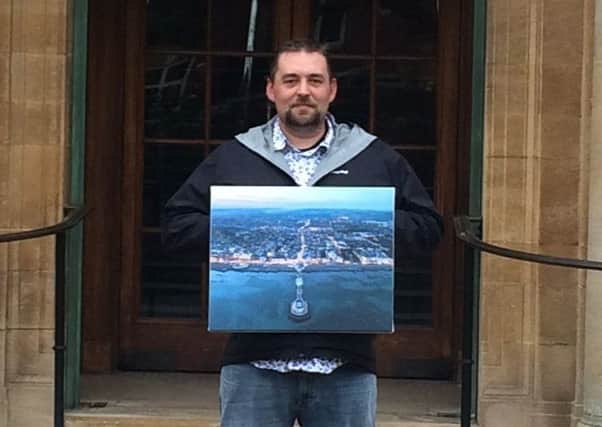 Matt Lewis visits County Hall to see his framed photograph, a stunning aerial view of Worthing Pier at night