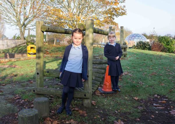 Year-two students Isla Howdle, front, and Daisy Wheatley with part of the play trail that is currently out of action