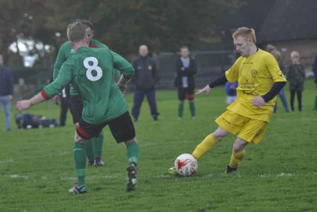 A Ninfield VFC player shapes to clip the ball out wide.