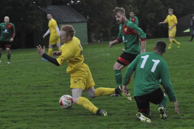 A Ninfield VFC player is upended by a Bexhill AAC II opponent.