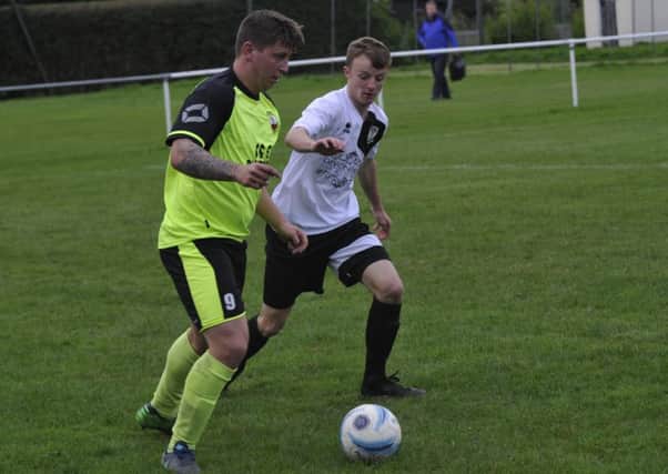 Bexhill United full-back Ben Cornelius keeps a close eye on Wick forward Josh Irish. Pictures by Simon Newstead