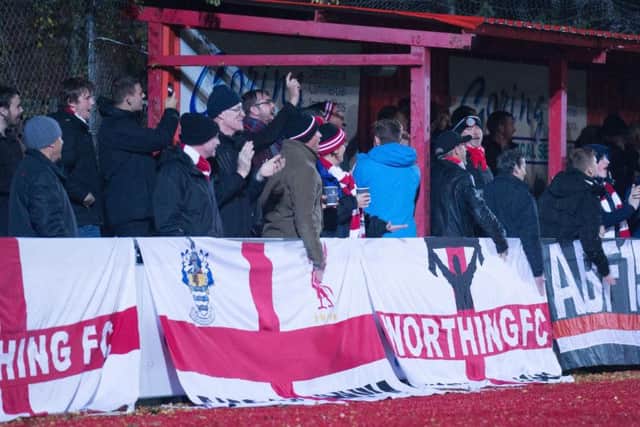 Worthing fans watch on in the wind and rain last night. Picture by Marcus Hoare