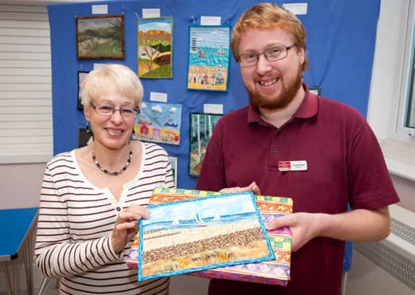 Jonathan Black presents Lynn Freeman with her prize for her quilted picture of East Beach In Littlehampton