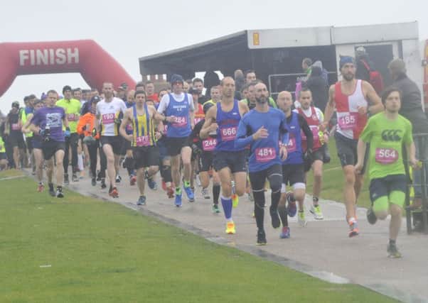 Runners set off in the wind and rain at the start of last year's Poppy Half Marathon. Picture by Simon Newstead
