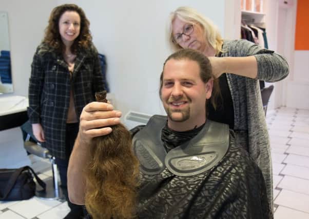 Mike Baker at Hairways with the 17 inches of hair he is donating to charity