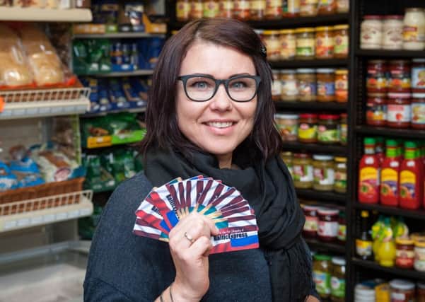Shop assistant Odeta Maskoliune with the reward cards for The Baltic Express in Wick Street, Wick. Picture: Scott Ramsey